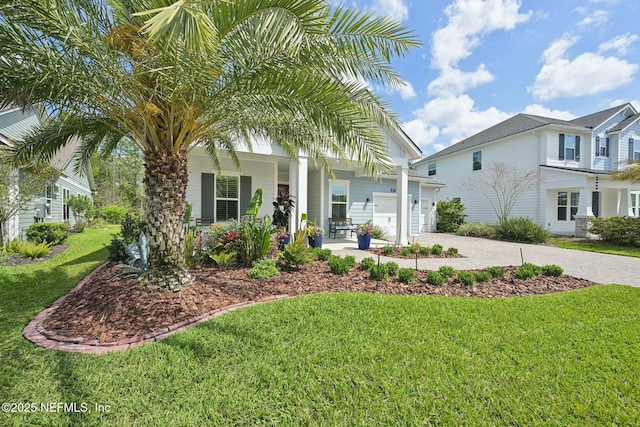 view of front of house featuring a porch, an attached garage, driveway, and a front lawn