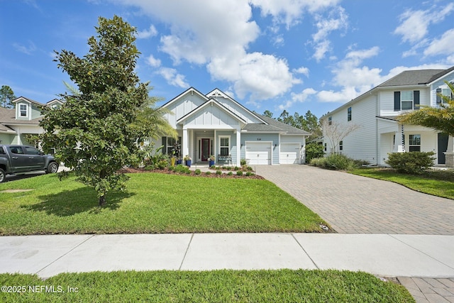 view of front facade featuring an attached garage, board and batten siding, a front yard, and decorative driveway
