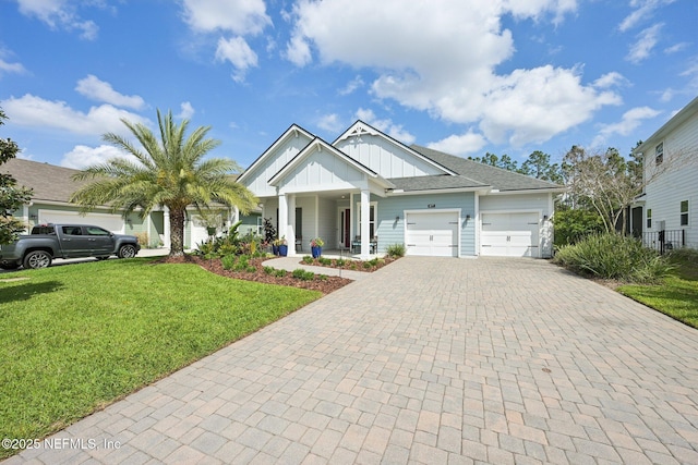 view of front of house featuring board and batten siding, decorative driveway, a front yard, a porch, and a garage