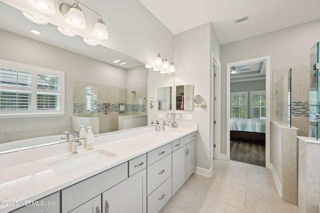 ensuite bathroom with walk in shower, visible vents, and a sink