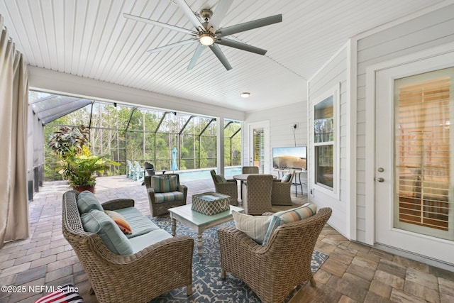 view of patio / terrace with an outdoor hangout area, outdoor dining space, ceiling fan, and glass enclosure