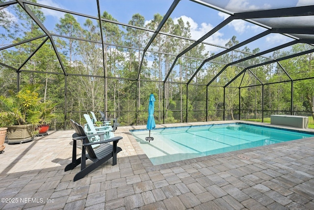 outdoor pool featuring a patio and glass enclosure