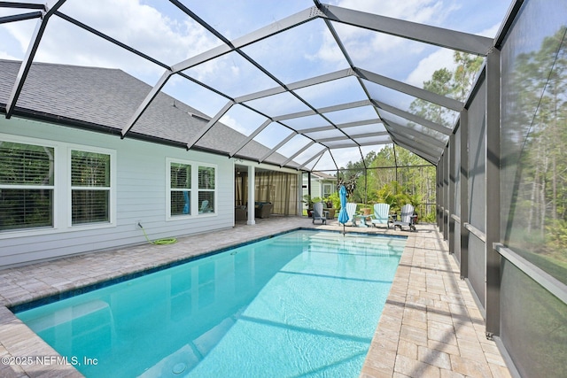 outdoor pool featuring a patio area and glass enclosure