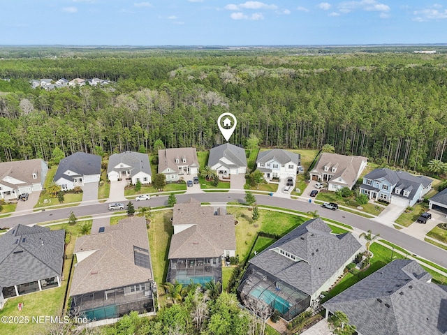 drone / aerial view featuring a view of trees and a residential view