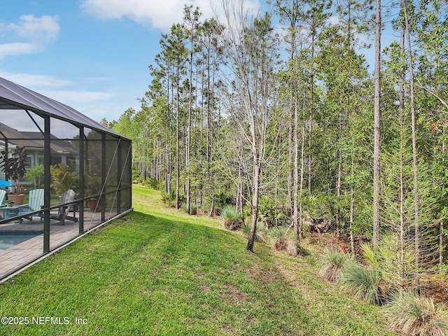 view of yard featuring an outdoor pool, a patio area, and glass enclosure