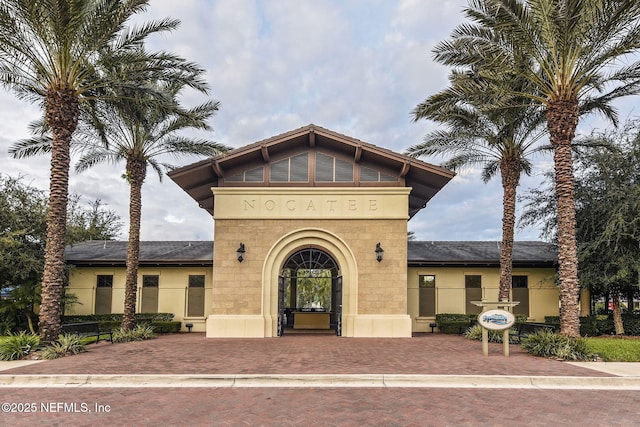 view of front of house with stucco siding and a shingled roof