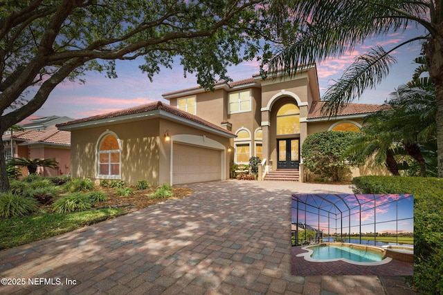 9 Cypresswood Dr, Palm Coast, FL 32137 - mediterranean / spanish home featuring a tiled roof, decorative driveway, a garage, stucco siding, and french doors