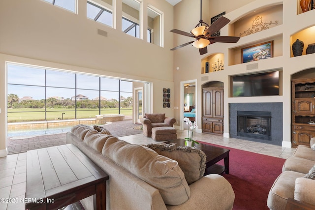 9 Cypresswood Dr, Palm Coast, FL 32137 - tiled living area featuring visible vents, ceiling fan, built in shelves, and a tile fireplace
