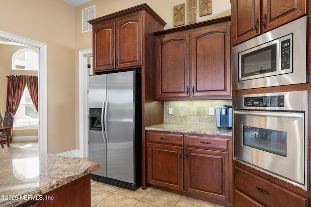9 Cypresswood Dr, Palm Coast, FL 32137 - kitchen with backsplash, stainless steel appliances, light stone counters, and visible vents