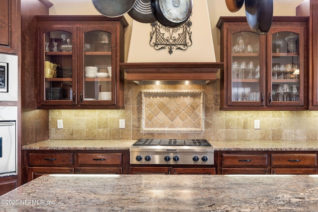9 Cypresswood Dr, Palm Coast, FL 32137 - kitchen featuring stainless steel gas stovetop, glass insert cabinets, tasteful backsplash, and oven