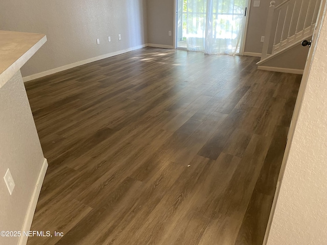 8550 Argyle Business Loop Unit 1308, Jacksonville, FL 32244 - unfurnished living room featuring stairs, dark wood-style floors, baseboards, and a textured wall