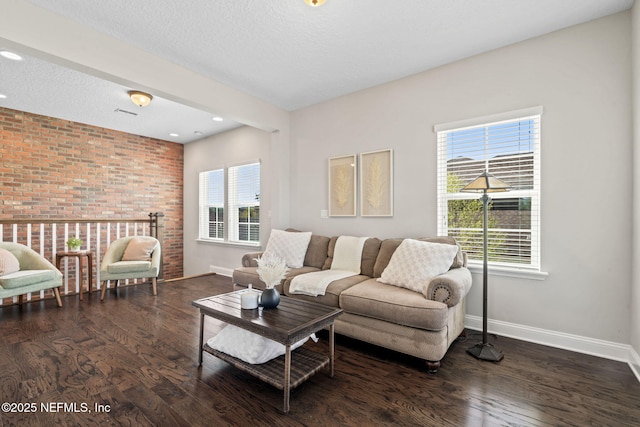211 Bronson Pkwy, Saint Augustine, FL 32095 - living room featuring baseboards, wood finished floors, brick wall, and a textured ceiling