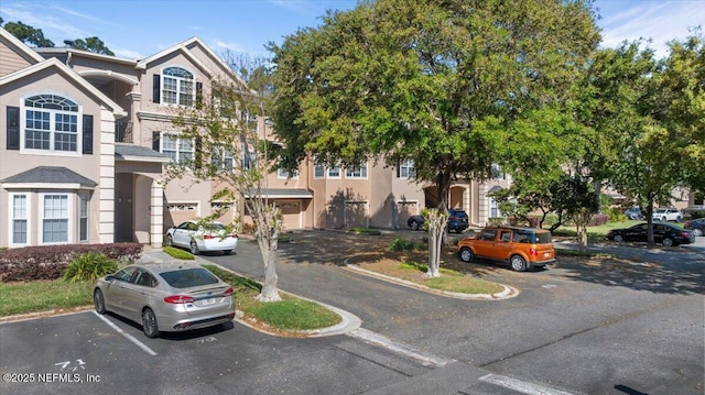 view of front facade with uncovered parking and stucco siding