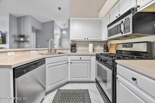 kitchen with white cabinetry, marble finish floor, a sink, a peninsula, and appliances with stainless steel finishes