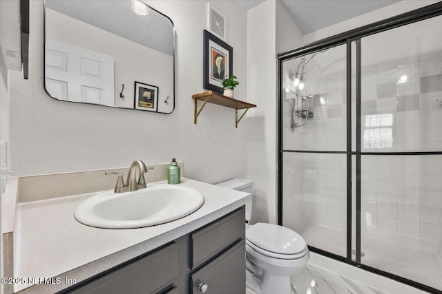 bathroom featuring visible vents, a stall shower, toilet, and vanity