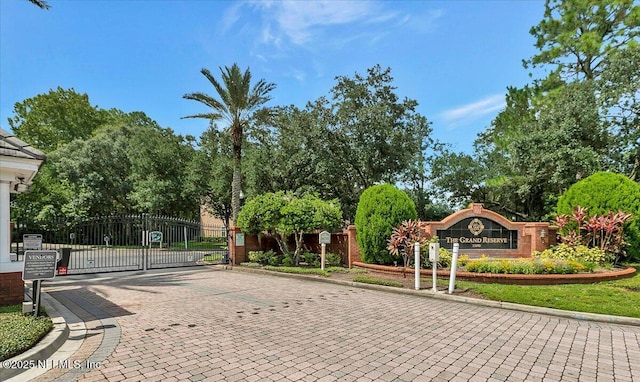view of road with a gate, a gated entry, and curbs