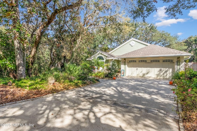 view of front facade featuring driveway, stucco siding, roof with shingles, and an attached garage