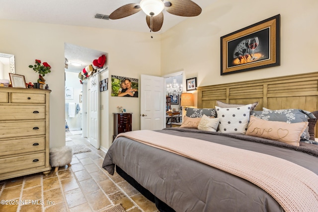bedroom with connected bathroom, visible vents, stone tile floors, and ceiling fan