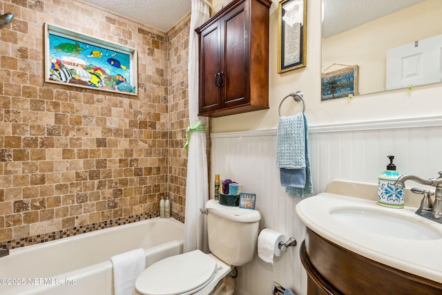 bathroom with a wainscoted wall, shower / tub combo, toilet, and a textured ceiling