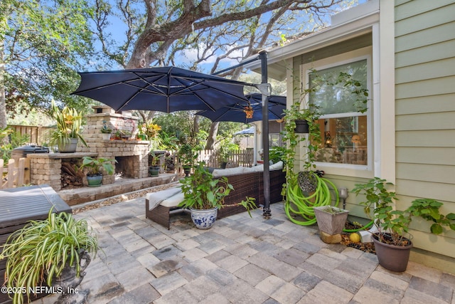 view of patio / terrace with an outdoor living space with a fireplace and fence