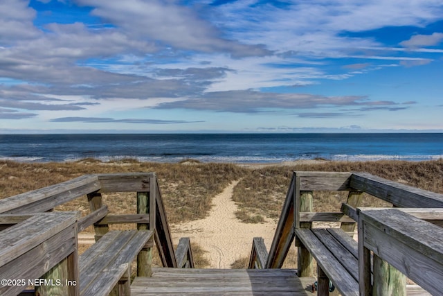 view of community with a water view and a beach view