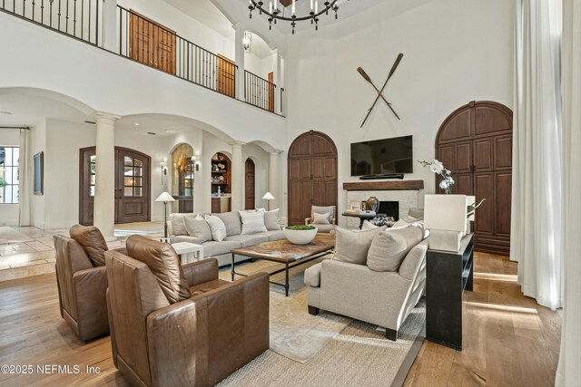 113 Cutter Ct, Ponte Vedra Beach, FL 32082 - living area with arched walkways, decorative columns, light wood finished floors, and a towering ceiling