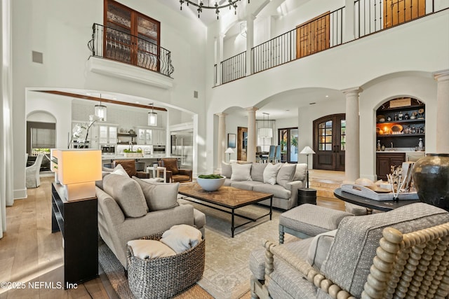 113 Cutter Ct, Ponte Vedra Beach, FL 32082 - living room featuring decorative columns, visible vents, arched walkways, wood finished floors, and a high ceiling