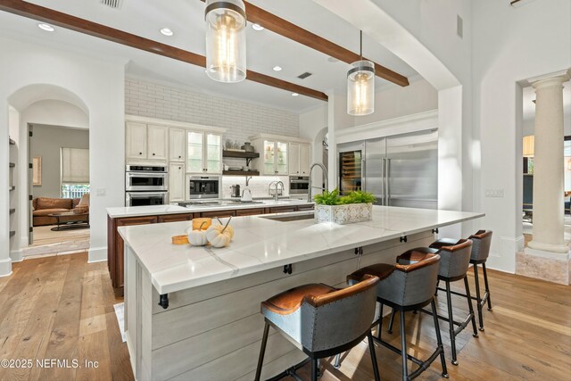 113 Cutter Ct, Ponte Vedra Beach, FL 32082 - kitchen featuring light wood-type flooring, beam ceiling, a spacious island, and stainless steel appliances