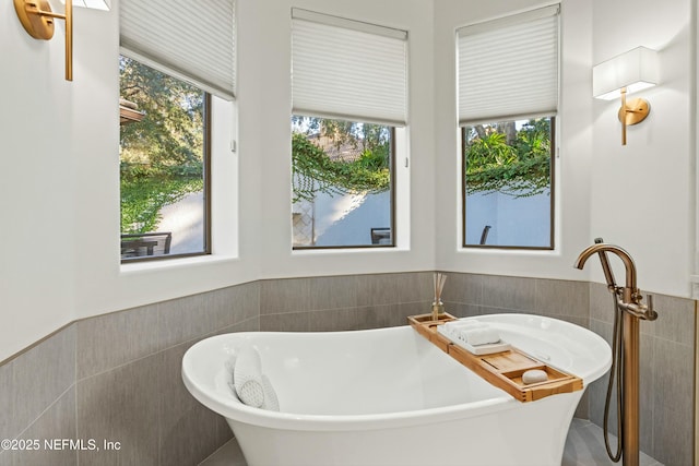 113 Cutter Ct, Ponte Vedra Beach, FL 32082 - full bath featuring a soaking tub, tile walls, wainscoting, and a healthy amount of sunlight