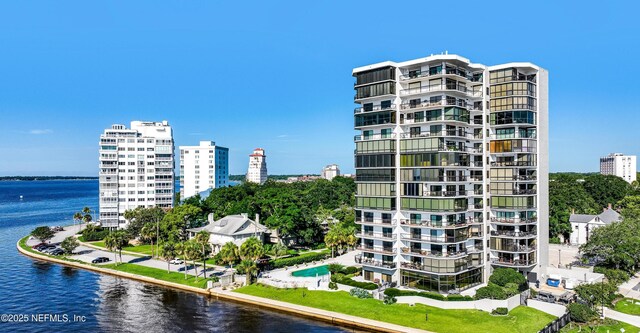view of building exterior featuring a water view and a view of city
