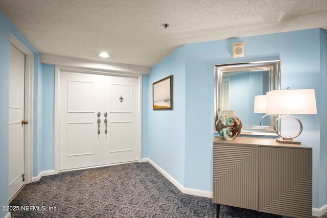 entrance foyer featuring carpet flooring, recessed lighting, baseboards, and a textured ceiling