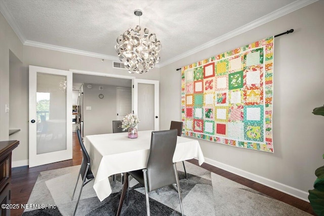 dining space with a notable chandelier, a textured ceiling, baseboards, ornamental molding, and dark wood-style flooring