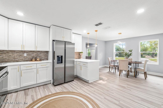 4488 Turner Ave, Jacksonville, FL 32207 - kitchen with light countertops, stainless steel fridge, a peninsula, tasteful backsplash, and white cabinetry