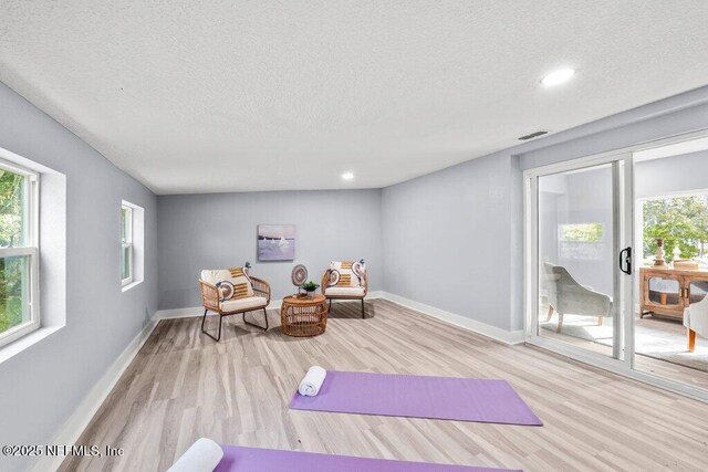 4488 Turner Ave, Jacksonville, FL 32207 - workout area featuring wood finished floors, a textured ceiling, and a wealth of natural light