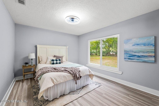 4488 Turner Ave, Jacksonville, FL 32207 - bedroom with baseboards, visible vents, a textured ceiling, and wood finished floors