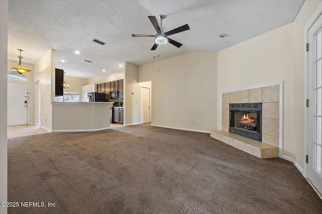 unfurnished living room with carpet floors, a ceiling fan, a textured ceiling, and visible vents
