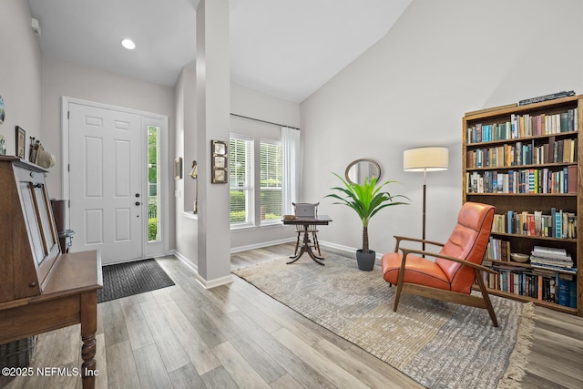 entryway with baseboards, recessed lighting, wood finished floors, and high vaulted ceiling