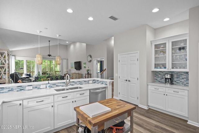 kitchen with visible vents, decorative backsplash, glass insert cabinets, a sink, and dishwasher