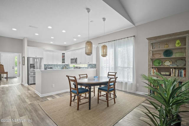 dining room featuring recessed lighting, baseboards, and light wood-style flooring