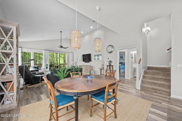 dining room featuring baseboards, a ceiling fan, wood finished floors, and stairway