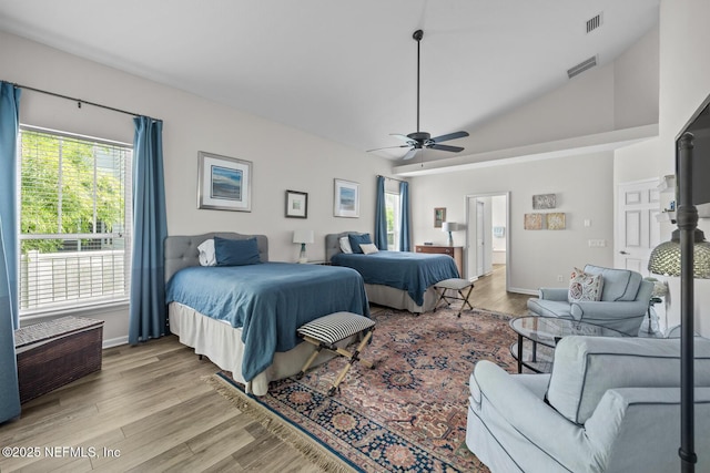 bedroom with visible vents, light wood finished floors, baseboards, and vaulted ceiling