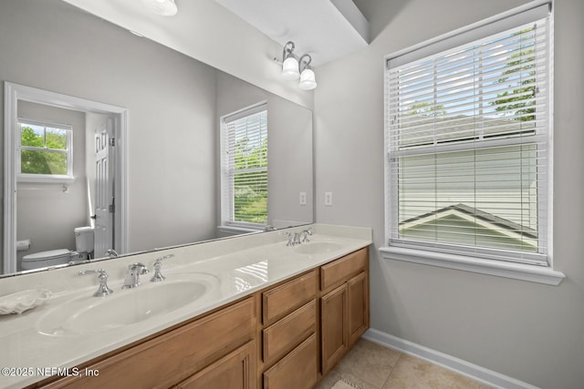 full bath featuring double vanity, a sink, tile patterned floors, and toilet