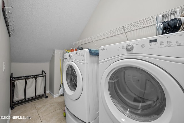 laundry area featuring light tile patterned floors, baseboards, laundry area, and washer and dryer