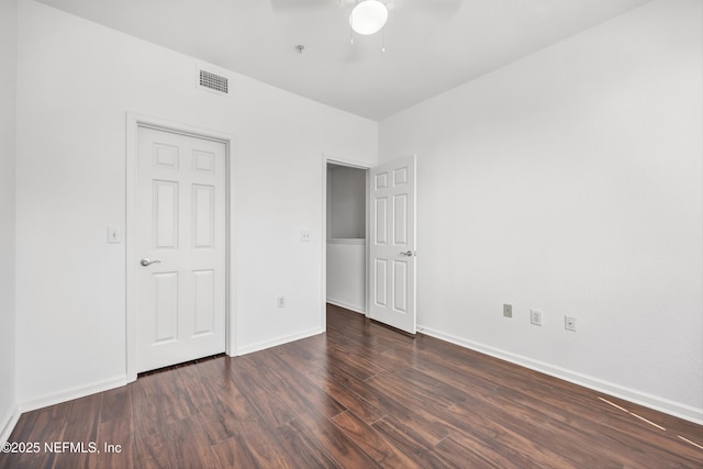 unfurnished bedroom with baseboards, ceiling fan, visible vents, and wood finished floors