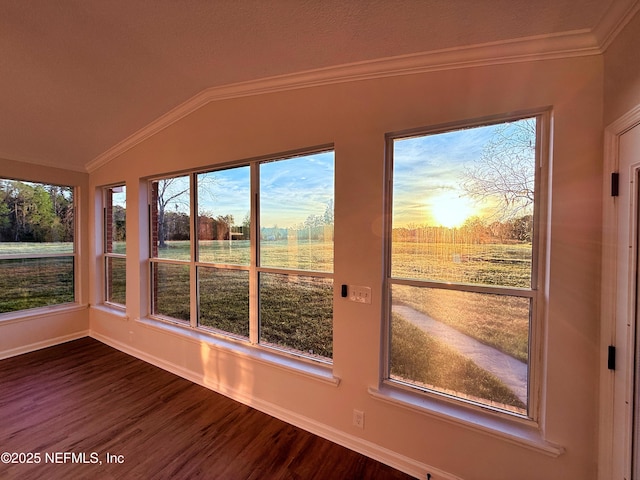 unfurnished sunroom featuring baseboards, wood finished floors, vaulted ceiling, and crown molding