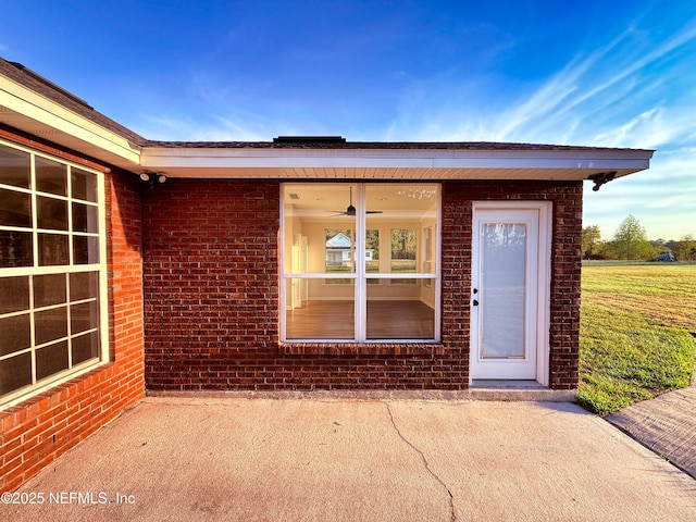 view of exterior entry featuring brick siding