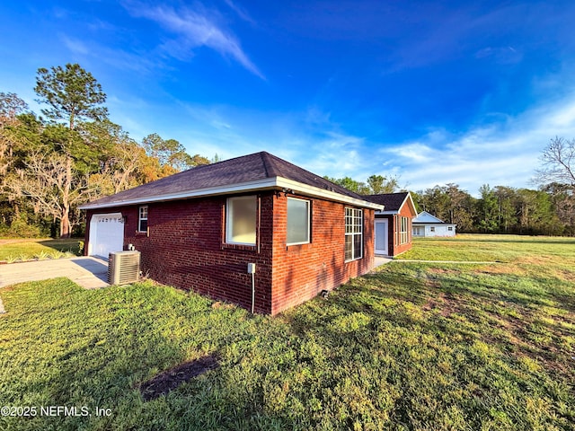 view of side of property featuring a lawn, driveway, a garage, and brick siding