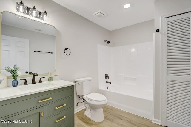 bathroom with vanity, toilet, visible vents, a closet, and wood finished floors
