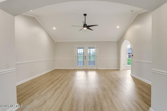 spare room featuring vaulted ceiling, arched walkways, french doors, and a ceiling fan