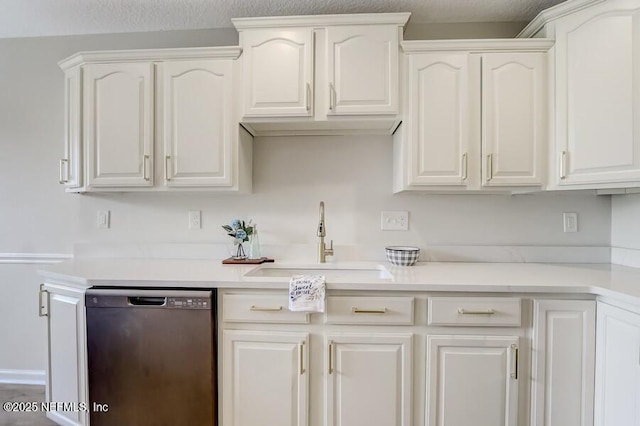 kitchen with dishwashing machine, white cabinets, light countertops, and a sink